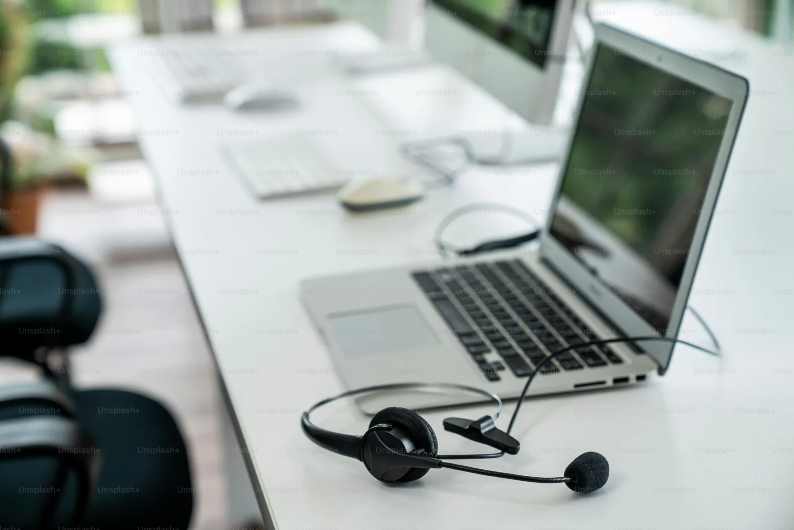 Headset resting beside a laptop in a calm workspace