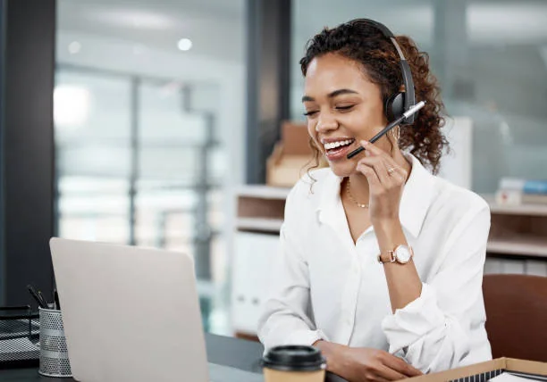 Person working with a phone and laptop at a desk